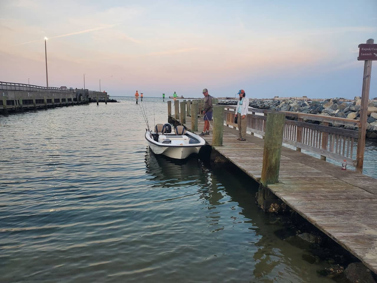 Have your helper move the boat down the pier and well away from the ramp, so others can use it while you park.