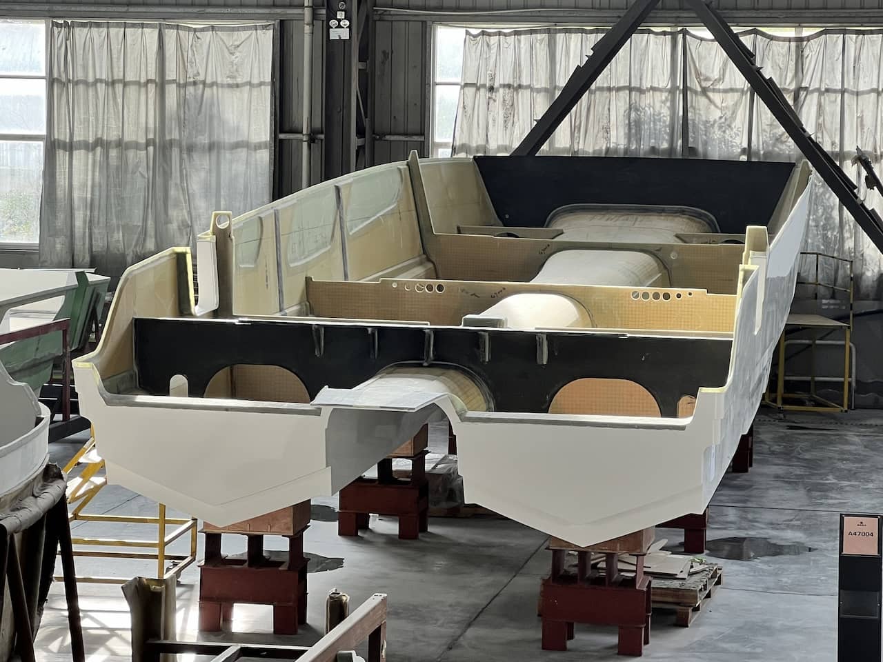 An Aquila 47 Molokai hull under construction with fore-and-aft carbon fiber bulkheads